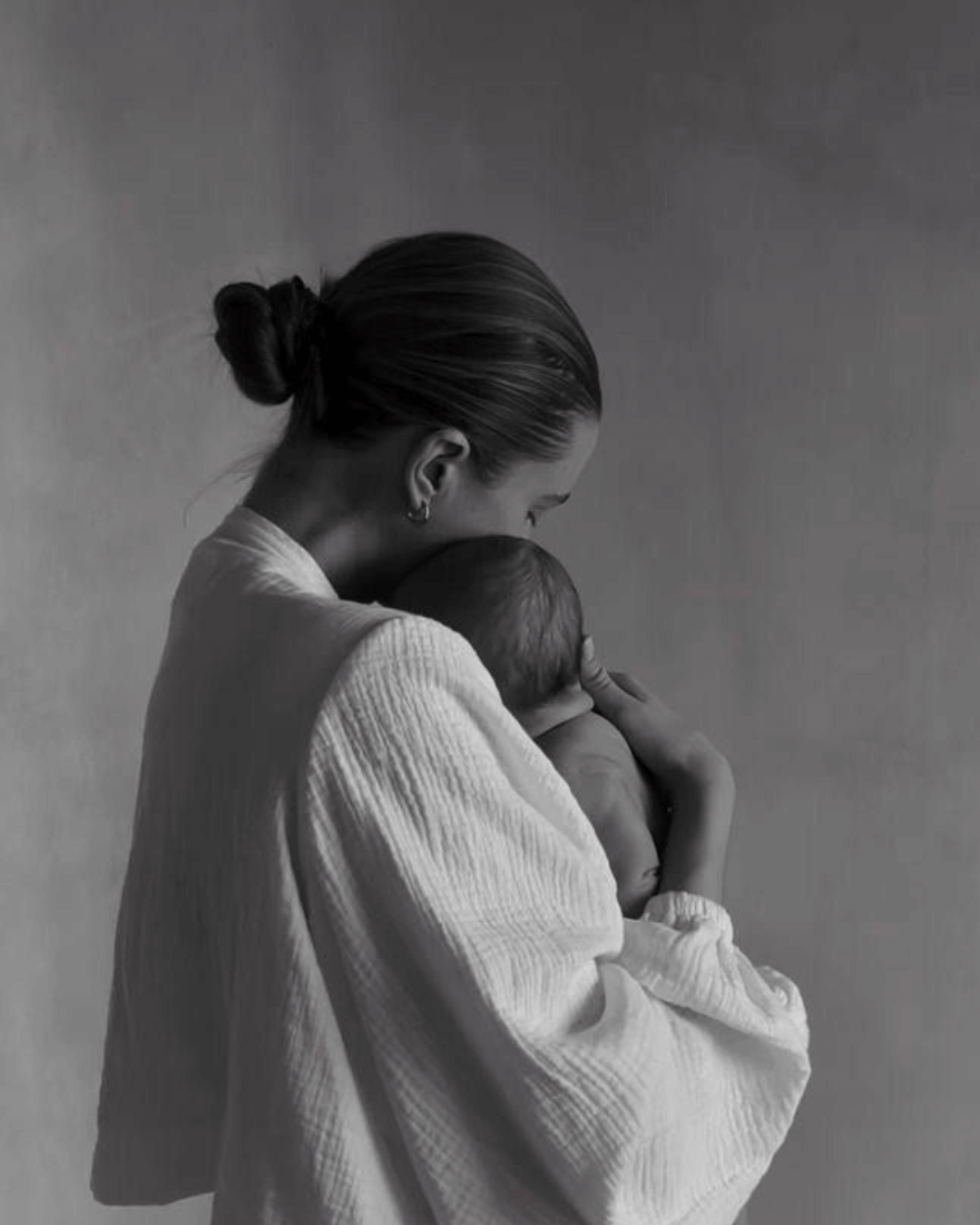 Mother holding newborn at home representing trauma-informed postpartum therapy support for anxiety, birth trauma, and emotional healing.